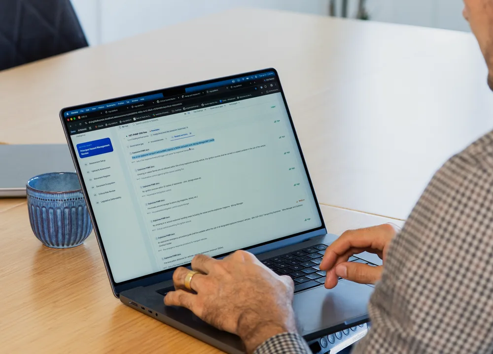 An engineer working at a laptop showing running software